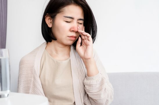Woman touching her nose while experiencing nasal discomfort