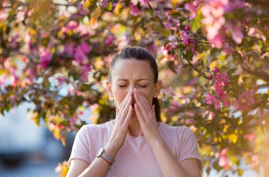 young woman sneezing